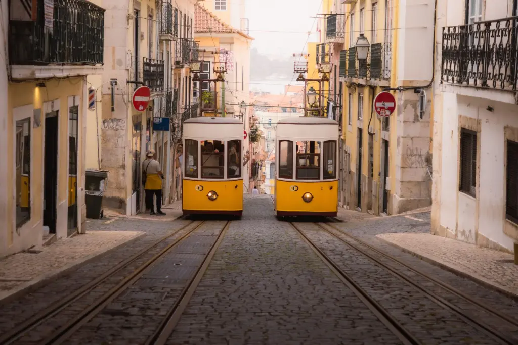 Iconic yellow vintage tram climbing the historic streets of Lisbon, a perfect weekend getaway from Madrid for international students.